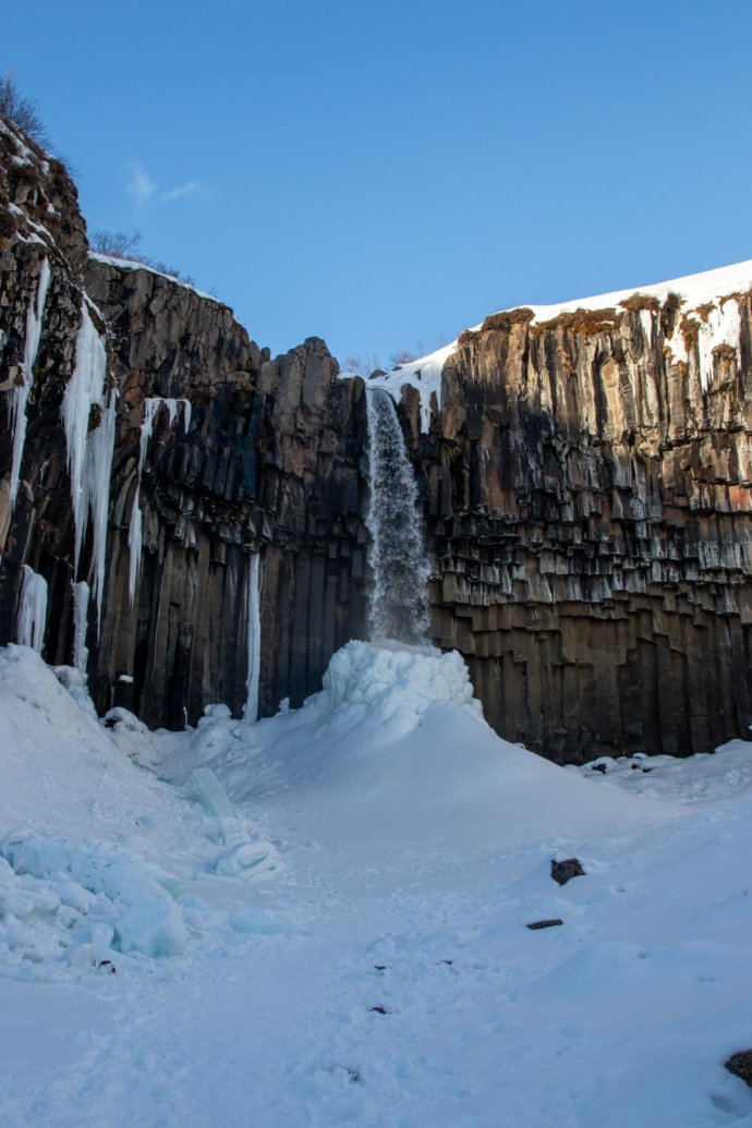 Cono de nieve en la base de la cascada de Svartifoss
