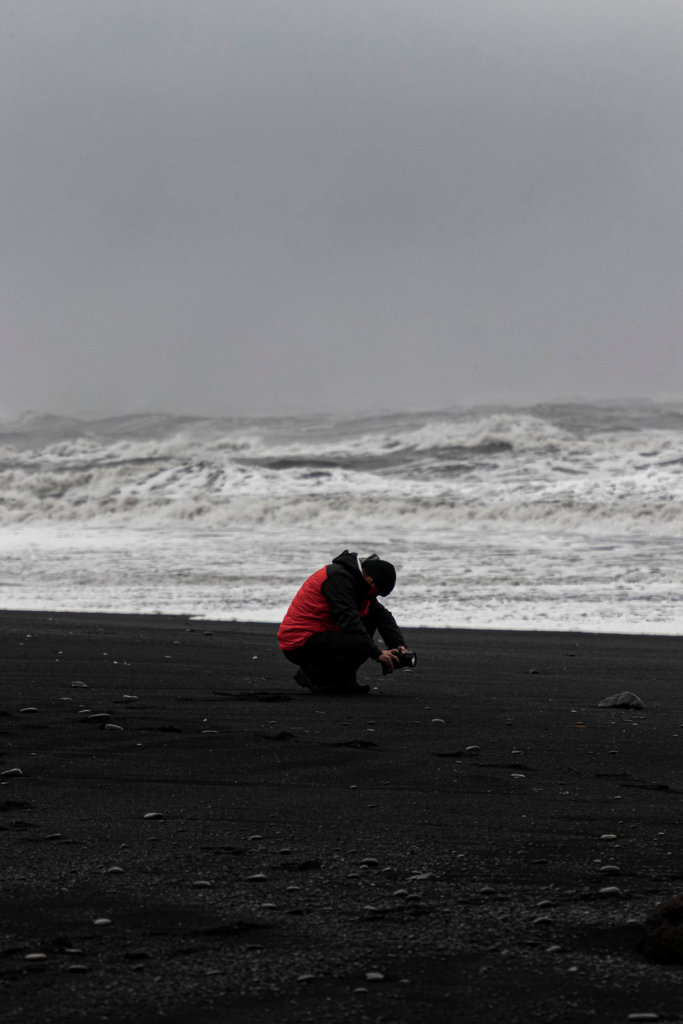 Pablo fotografía los roques de Reynisdrangar mientras vigila la subida del mar.
